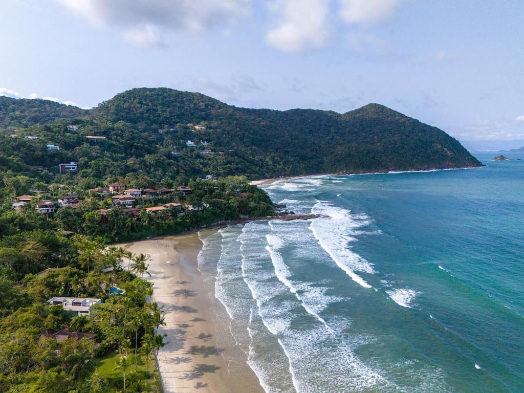 an aerial view of a beach with trees and the ocean at Villa in the middle of the Atlantic Forest in Guarujá