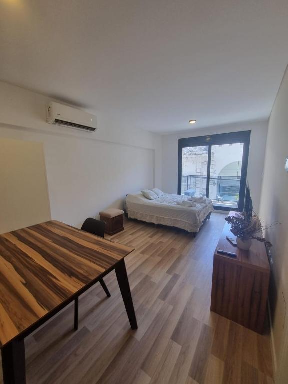 a bedroom with a bed and a table in a room at Temporario Rosario 9 in Rosario