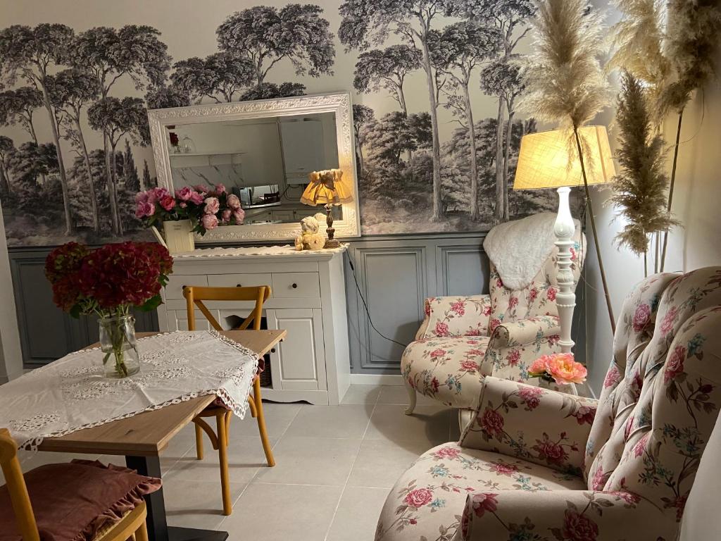 a living room with a table and chairs and a mirror at La petite maison in Solesmes