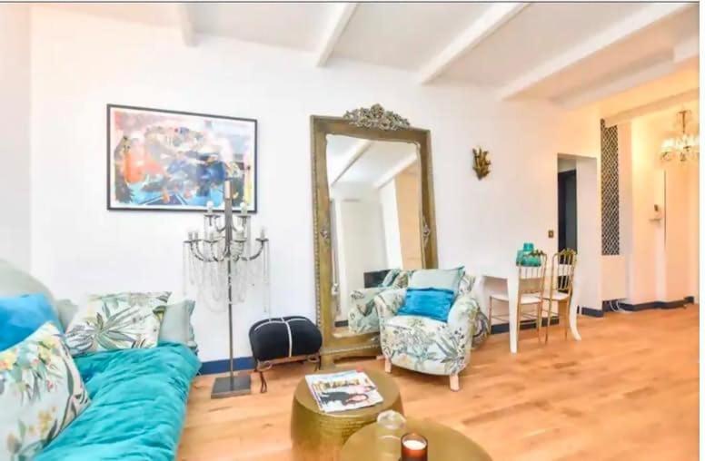 un salon avec un canapé bleu et un miroir dans l'établissement Place du Trocadero 25 mins away, à Boulogne-Billancourt