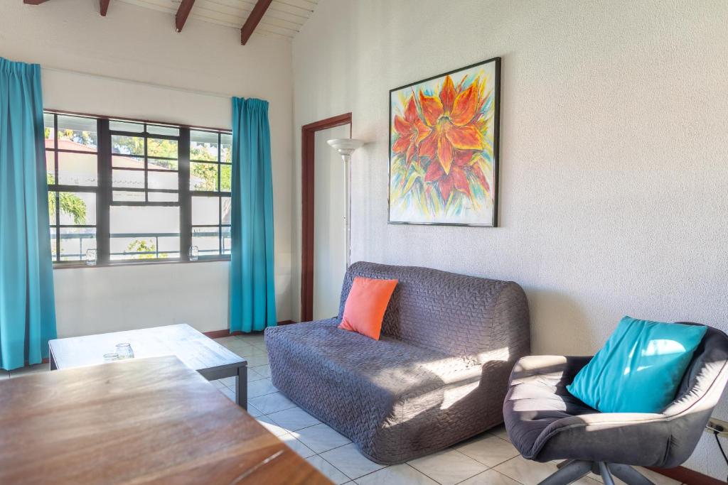 a living room with a couch and a chair and a table at Talk of the Town Inn & Suites - St Eustatius in Oranjestad
