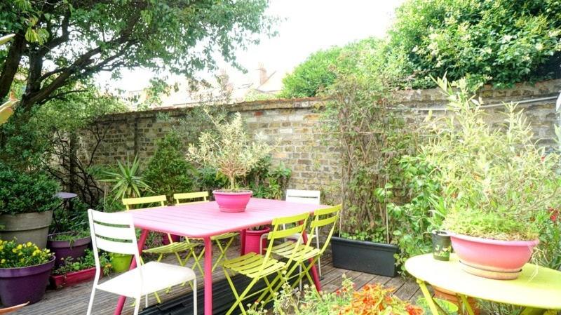 a pink table and chairs in a garden at Malo Les Bains House & Beach Garden 5 min walk in Malo-les-Bains