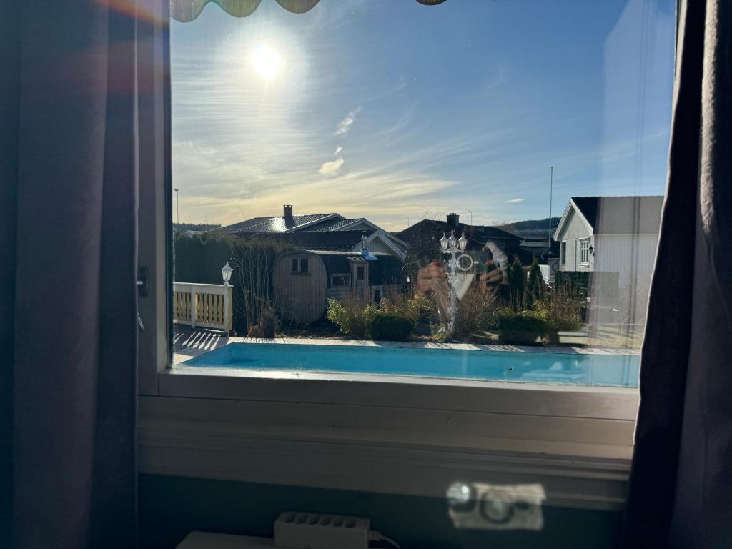 a window with a view of a swimming pool at Just Like Home Bed & Spa Porsgrunn in Porsgrunn