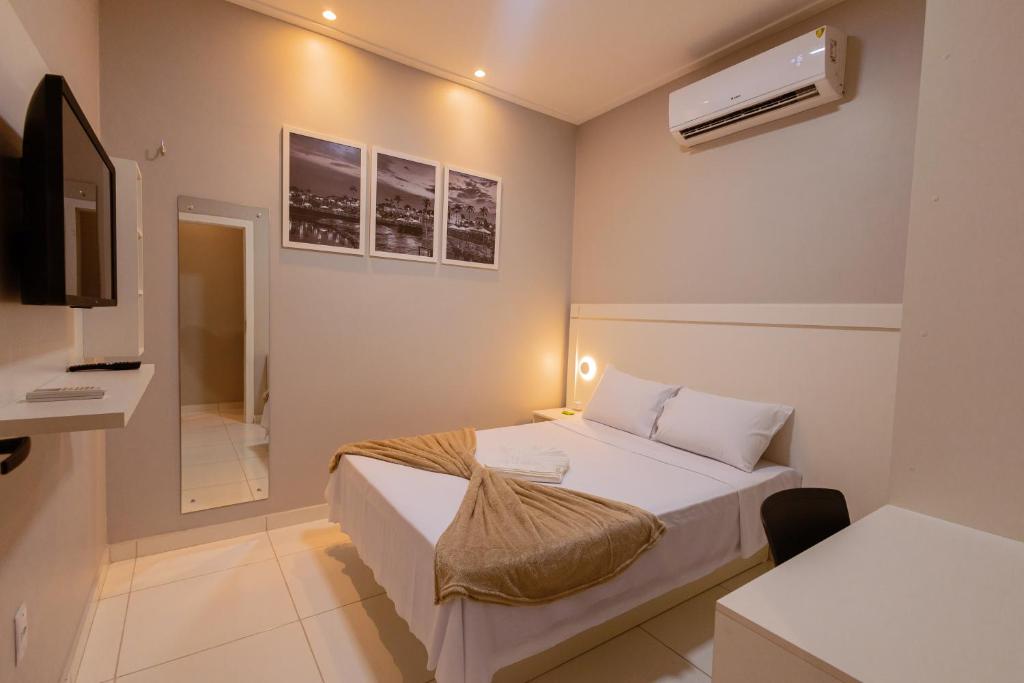 a small bedroom with a bed and a television at LOFT Bragança Apart-hotel in Bragança