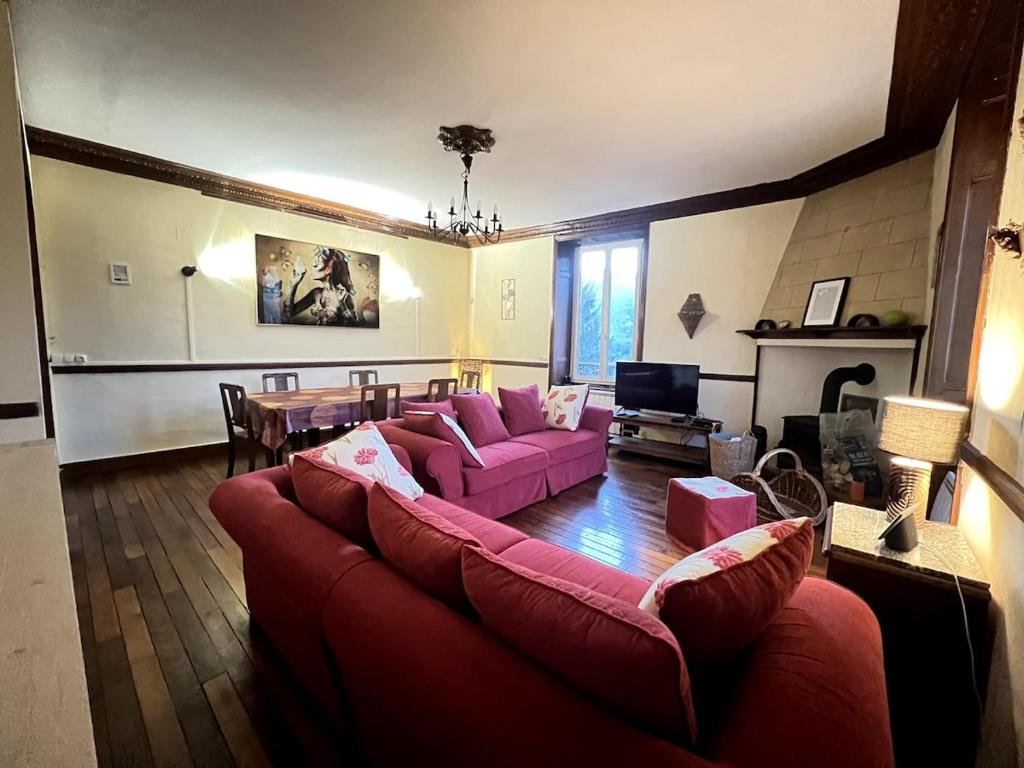 un salon avec un canapé rouge et une table dans l'établissement Nice authentic house, à Ardes-sur-Couze