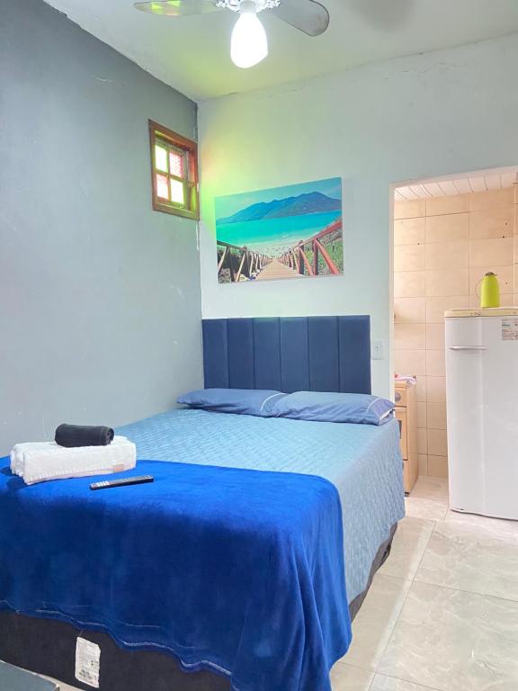 a bedroom with a bed with a blue blanket at Suíte Pé na Areia in Arraial do Cabo