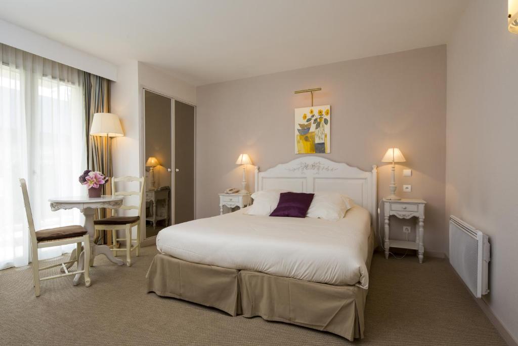 A bed or beds in a room at Tulip Inn Honfleur Residence & Spa