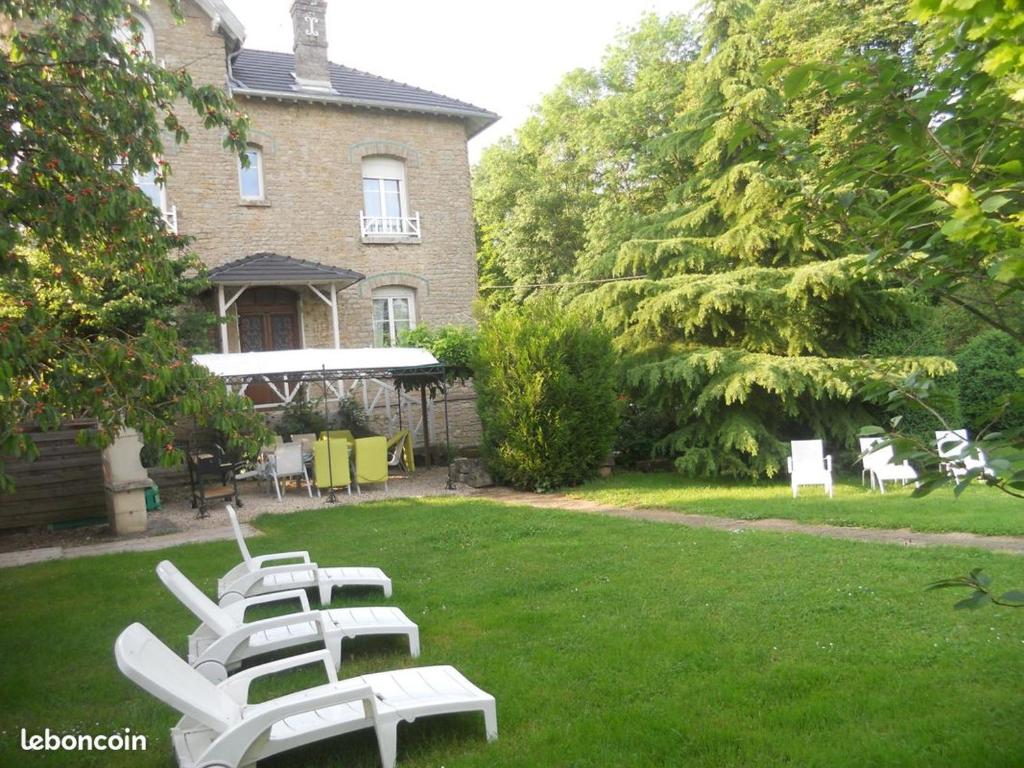une rangée de chaises de jardin blanches dans une cour dans l'établissement Gîtes à la ferme de la Seille Lorraine, à Létricourt