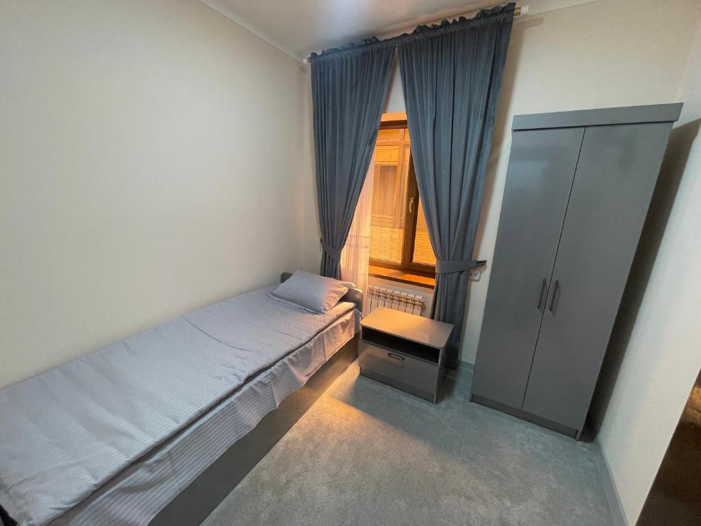 サマルカンドにあるGuesthouse Asteriya Гостевой домのベッドと窓のある小さな寝室