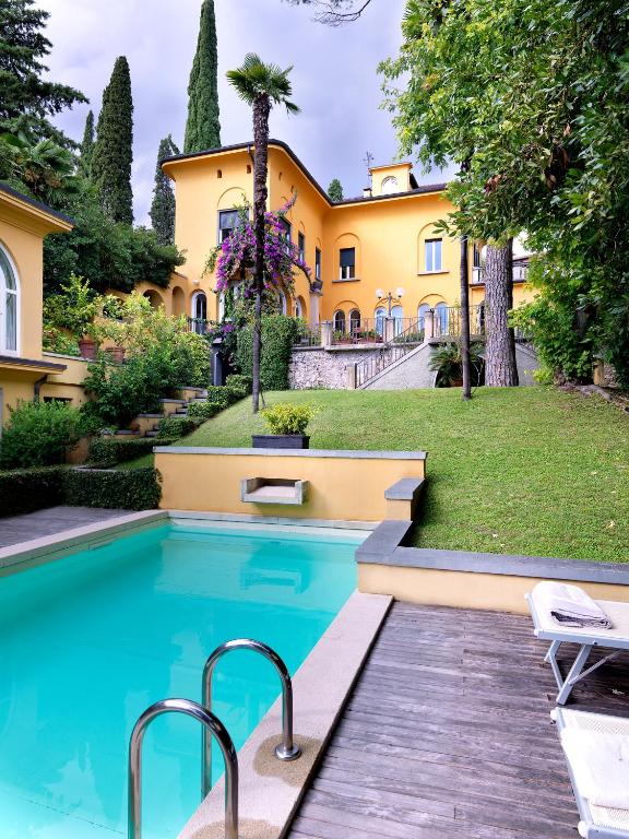 an estate with a swimming pool in front of a house at Villa Ella con Depandance in Gardone Riviera
