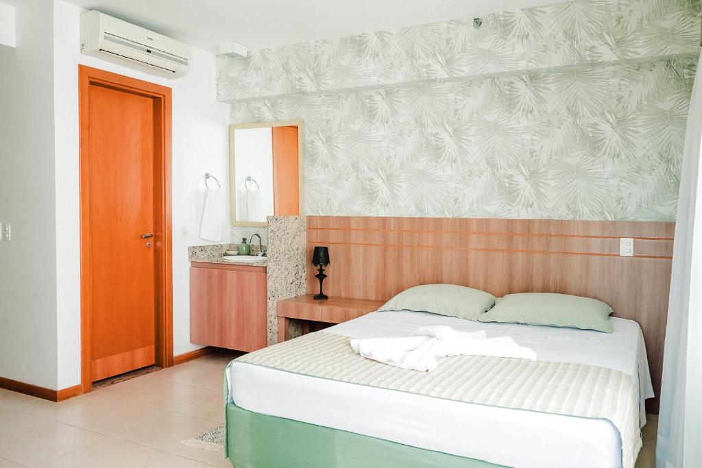 a bedroom with a large bed and a bathroom at Flat II em Saint Morizt Brasília Hotel in Brasilia