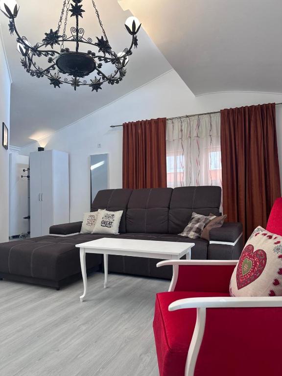 a living room with a black couch and a table at Central Park Bragadiru Loft in Bragadiru