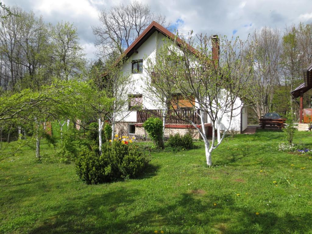 een wit huis in een veld van groen gras bij House Jezerka in Jezerce