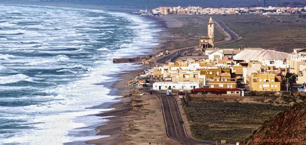 eine Gruppe von Häusern am Strand neben dem Meer in der Unterkunft Hotel las Salinas in Cabo de Gata