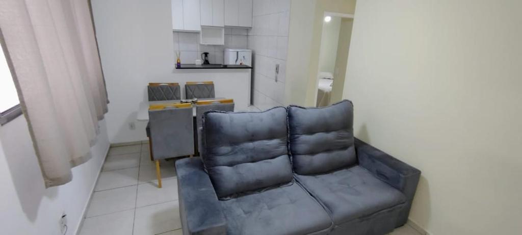a living room with a couch and a kitchen at Apto 2 quarto completo com vaga-proximo shopping contagem in Contagem