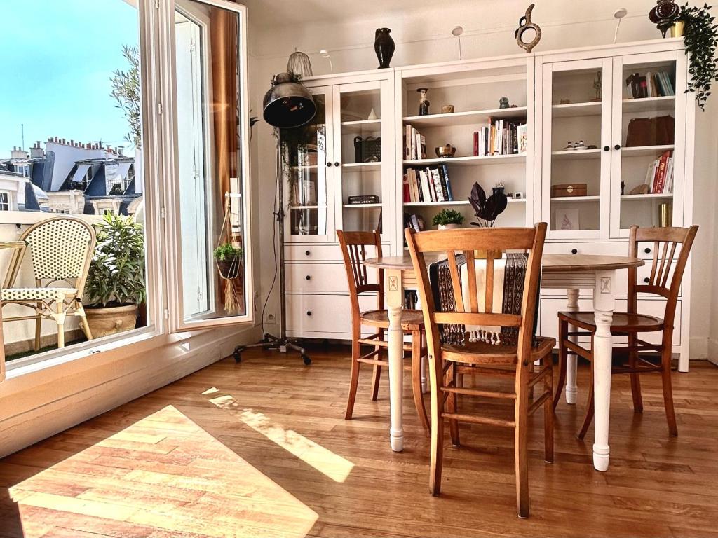 une salle à manger avec une table et des chaises et une fenêtre dans l'établissement Charming Parisian flat near Eiffel Tower - 3 rooms and balcony, à Paris