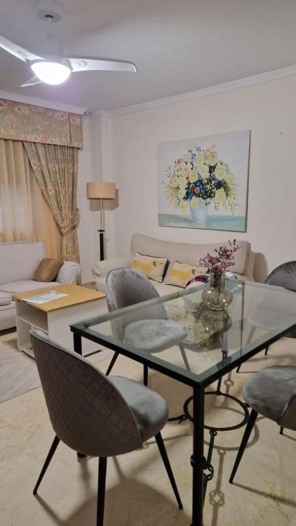 a living room with a glass table and chairs at Salusahome parking gratuito in Córdoba