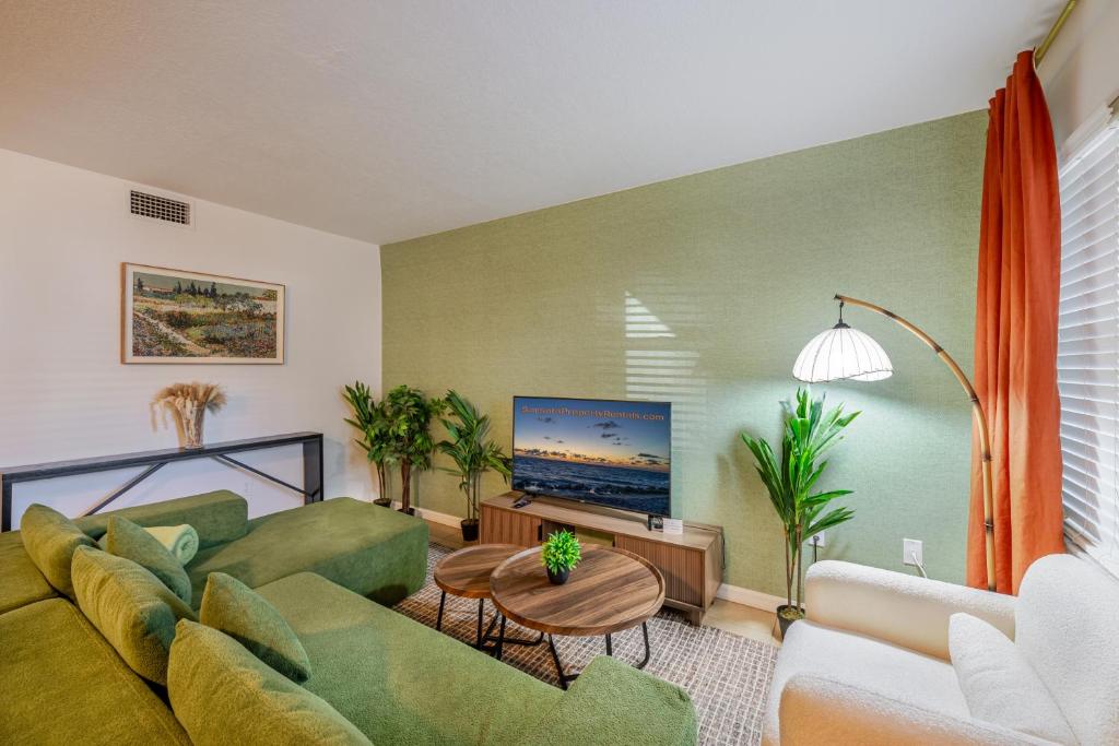 a living room with a couch and a tv at Vibrant Modern Escape, Walk To Dining, Near Beach in Sarasota