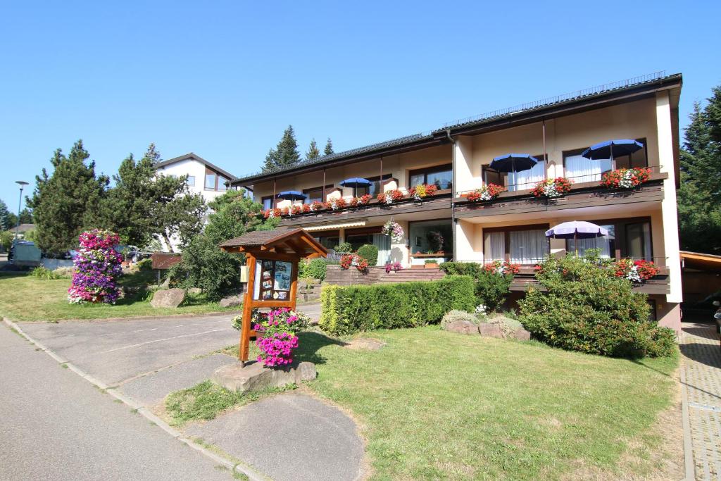 ein Gebäude mit Blumen und Sonnenschirmen im Hof in der Unterkunft Gästehaus Schmid-Lopez in Bad Wildbad