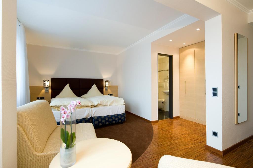 a hotel room with a bed and a table and chairs at Hotel Lücke Rheine in Rheine