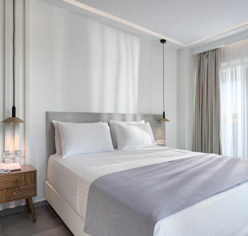 a white bedroom with a large bed and a window at Myzith Luxury Suites in Keri