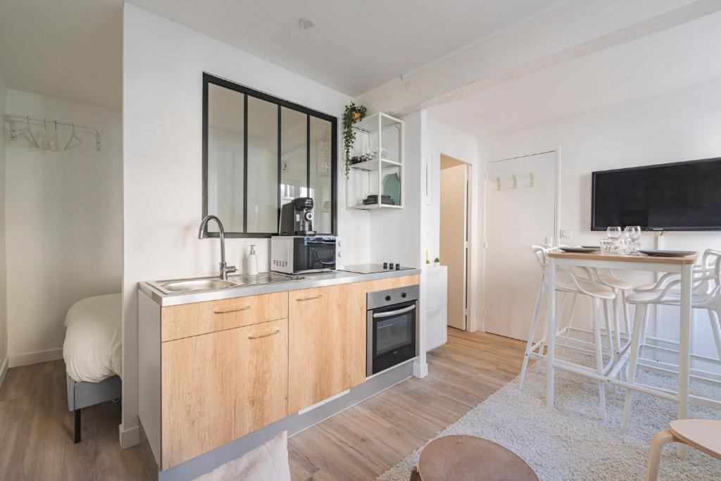 een keuken met een spoelbak en een aanrechtblad bij Oscaria, centre Reims, plein pied in Reims