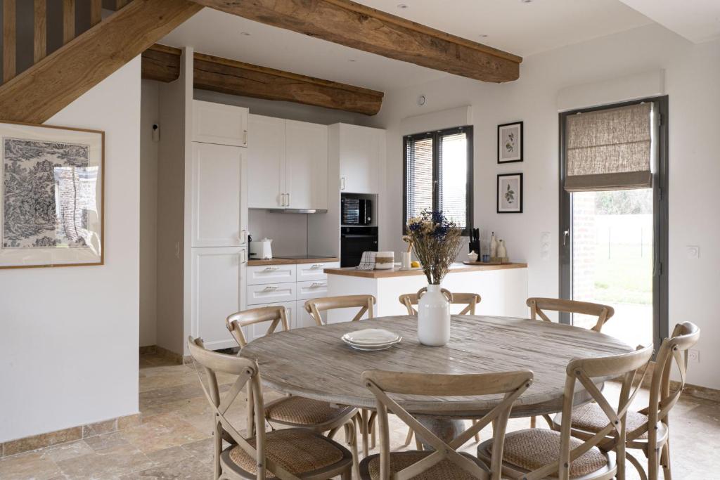 a kitchen and dining room with a table and chairs at Maison Castel A haven of peace near Deauville in Cricquebœuf