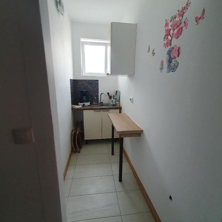 a small kitchen with a table and a window at Garsoniera in Ocniţa