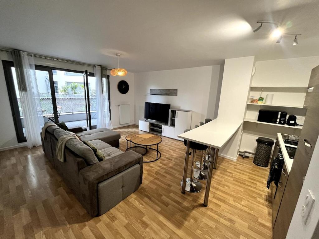 un salon avec un canapé et une table dans l'établissement Nice flat in la Plaine St Denis, à Saint-Denis