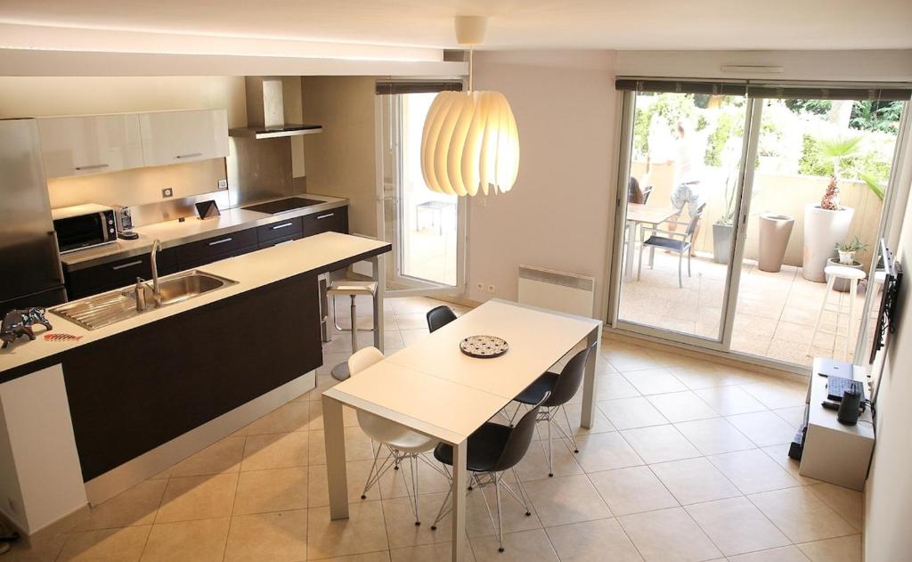 une cuisine avec une table et des chaises ainsi qu'une salle à manger dans l'établissement T3 TERRASSE SUD Marseille 13009, PARC DES CALANQUES, à Marseille
