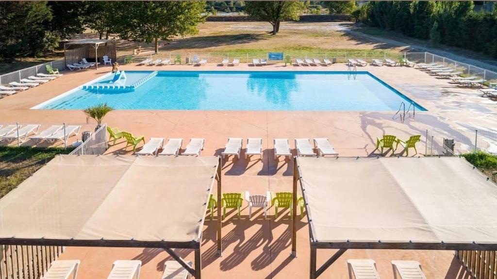 - une vue sur la piscine et ses chaises longues dans l'établissement Mobilhome 6 personnes, à Cheval-Blanc