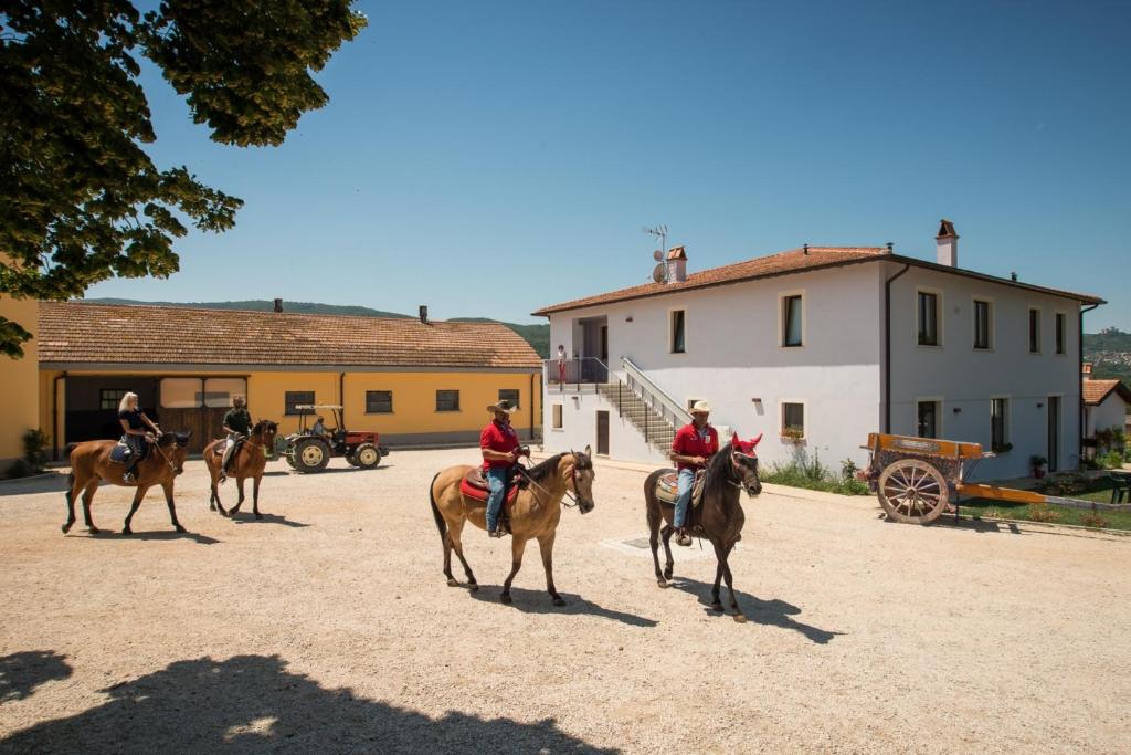 un grupo de gente montando caballos en un camino de tierra en Fattoria Didattica La Collina Incantata en Narni