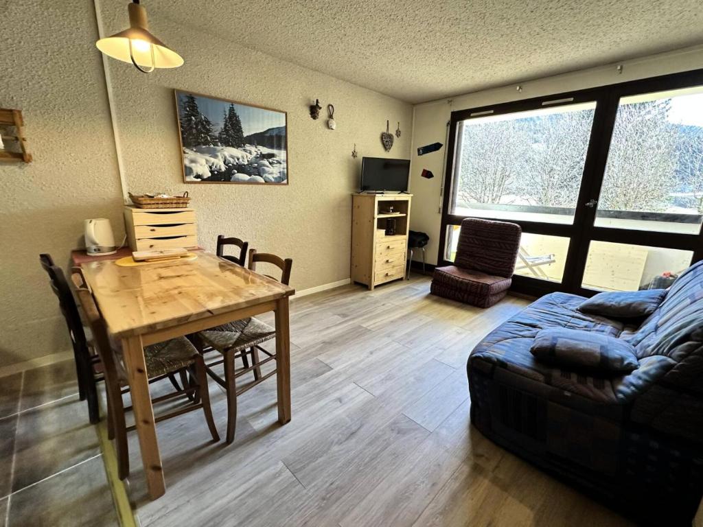 ein Wohnzimmer mit Tisch und Couch in der Unterkunft Résidence Carette - STUDIO 32 M² CLOS DE LA BALME MAE-4841 in Corrençon-en-Vercors