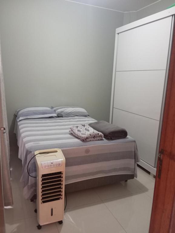 a small bedroom with a bed with a fan at Casa Completa in Cascavel