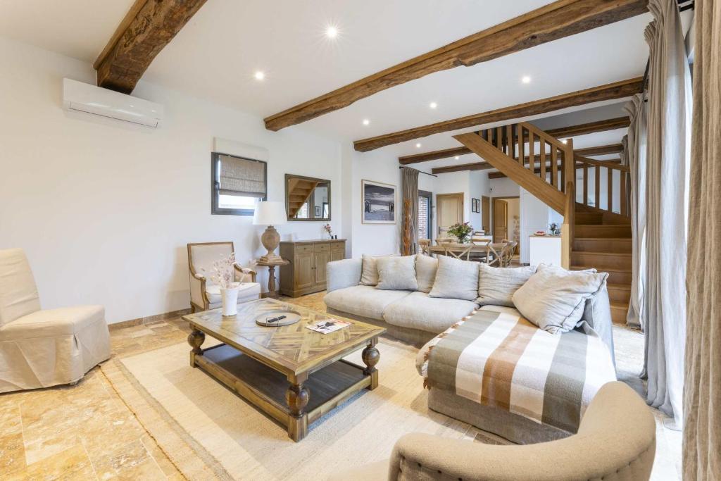 un salon avec un canapé et une table dans l'établissement Maison Melrose Lovely house near Deauville, à Cricquebœuf