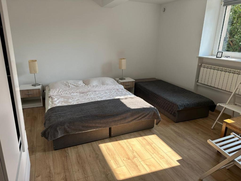 a bedroom with a bed and a bench and a window at Noclegi nad jeziorem Brdów Agroturystyka pod Wierzbą in Brdów
