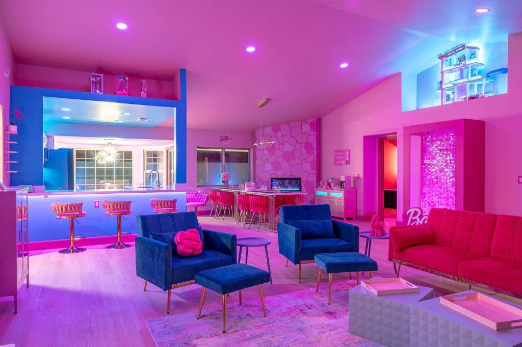 a living room with pink and blue furniture and a kitchen at Dollhouse Daydream! Barbie-Inspired Home in Peoria