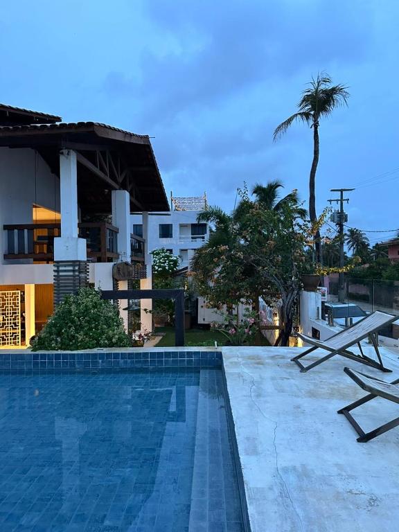 a swimming pool in front of a building at Inn Tribus Hotel in Flecheiras