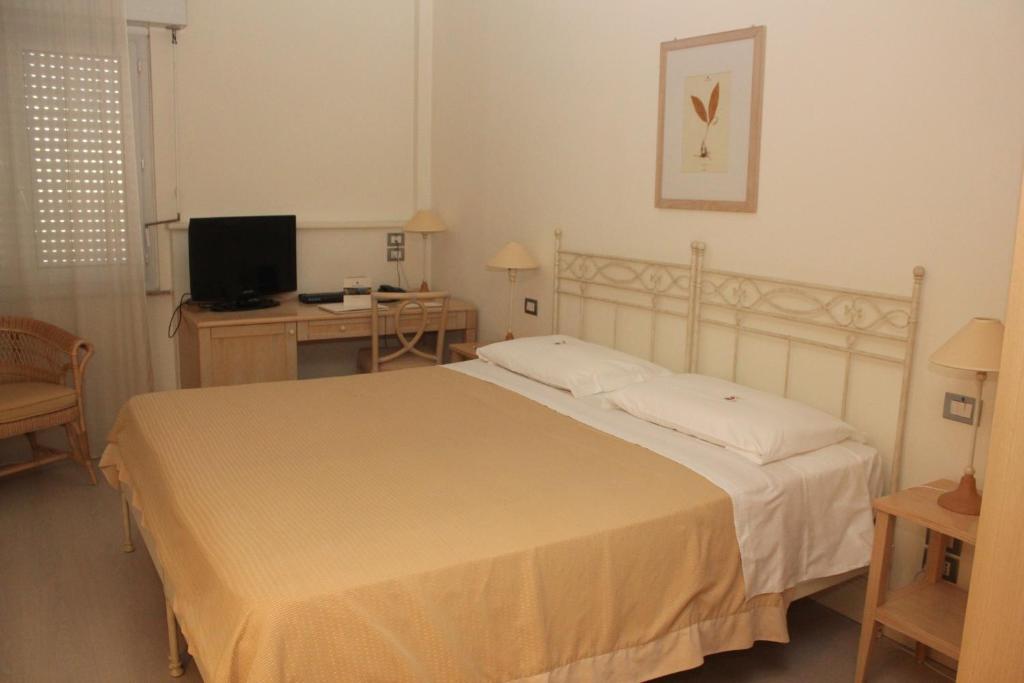 Postel nebo postele na pokoji v ubytování Hotel Sirolo