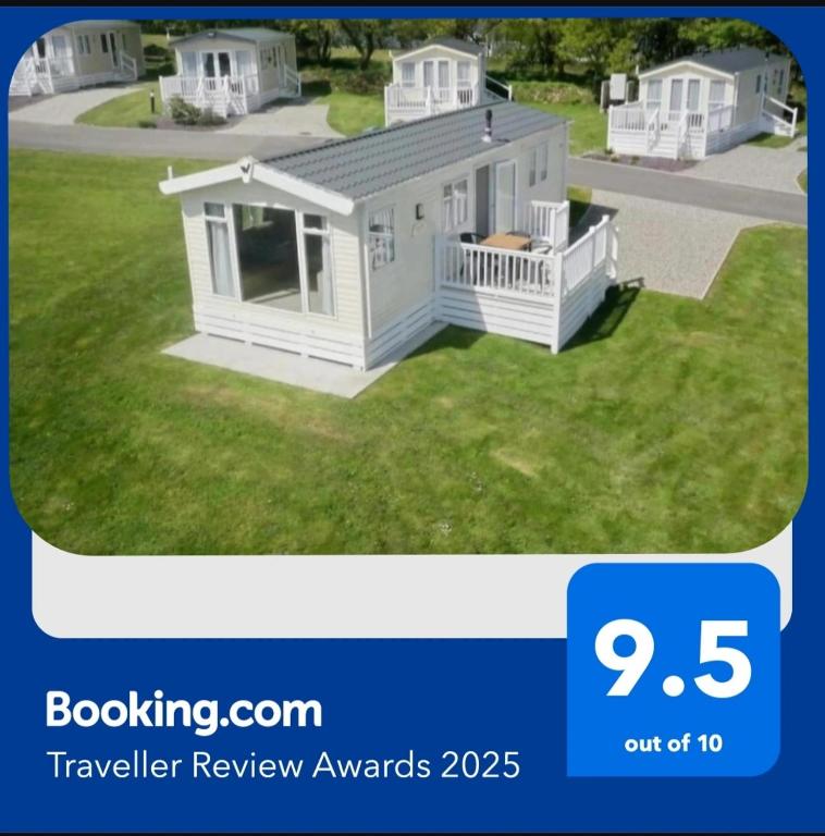 a picture of a white tiny house on a lawn at Holiday Home - St Austell in St Austell