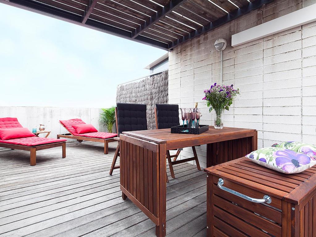 a patio with a table and chairs on a deck at My Space Barcelona Guell Terrace Center in Barcelona