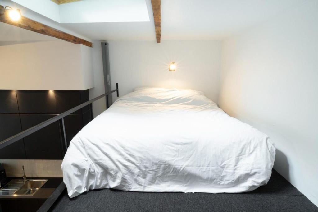 a bedroom with a bed with a white comforter at Studio 5 mn from Arc de triomphe - Champs-Élysées in Paris