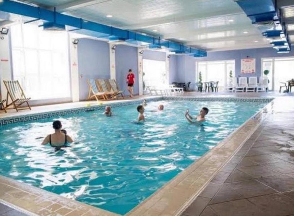 un grupo de personas en una piscina en Pet Friendly 3 Bed Static Caravan in Clarach Bay Spacious and Cozy Stay, en Aberystwyth