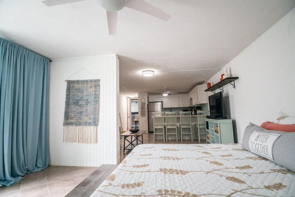 a bedroom with a large bed and a kitchen at Beach & Country Beachfront Studio in Hauula