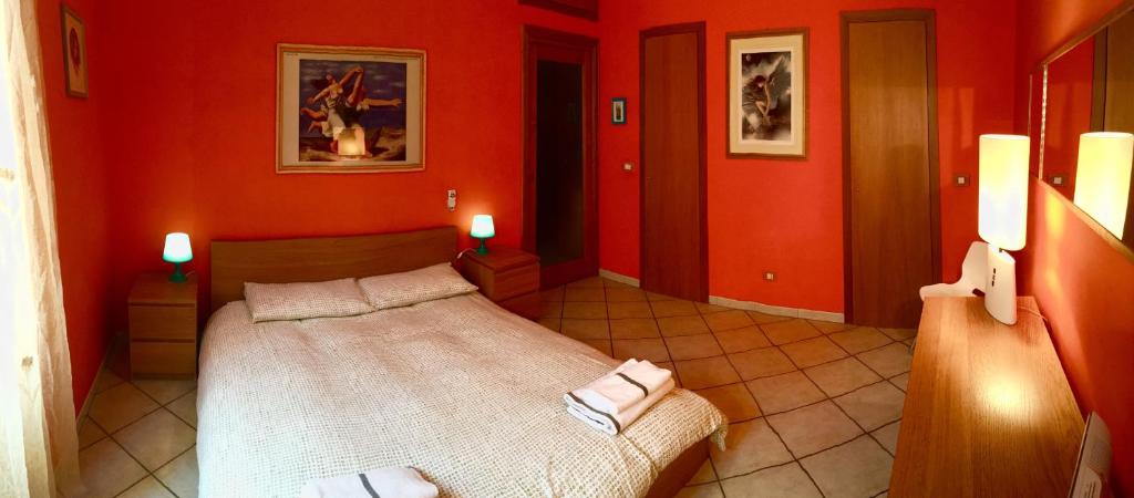 a red room with a bed with towels on it at Modì Apartment in Rome
