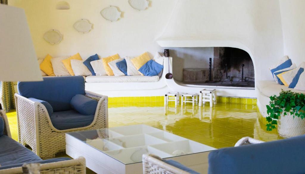 ein Wohnzimmer mit einem Sofa, Stühlen und einem Tisch in der Unterkunft Villa Gilda in Torre delle Stelle