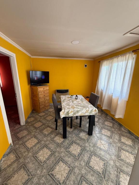 a dining room with a table and chairs and yellow walls at Vientos del Sur in Río Gallegos
