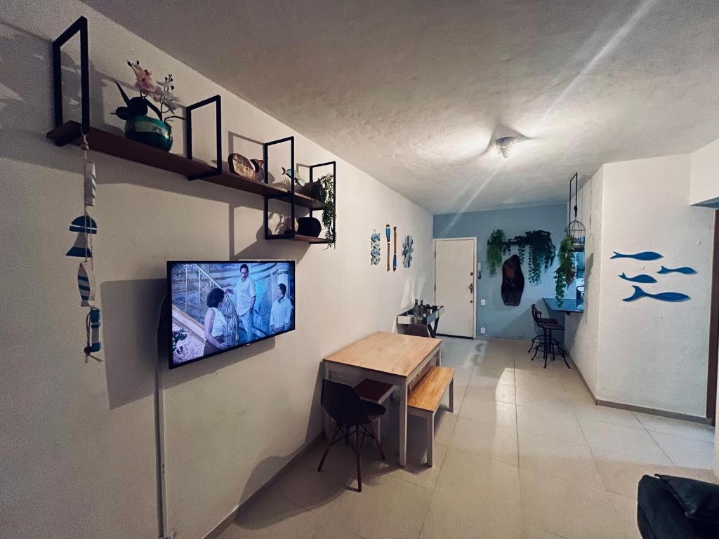 a living room with a television on a wall at Meu Loft Itauna 1 - Localização Privilegiada in Saquarema