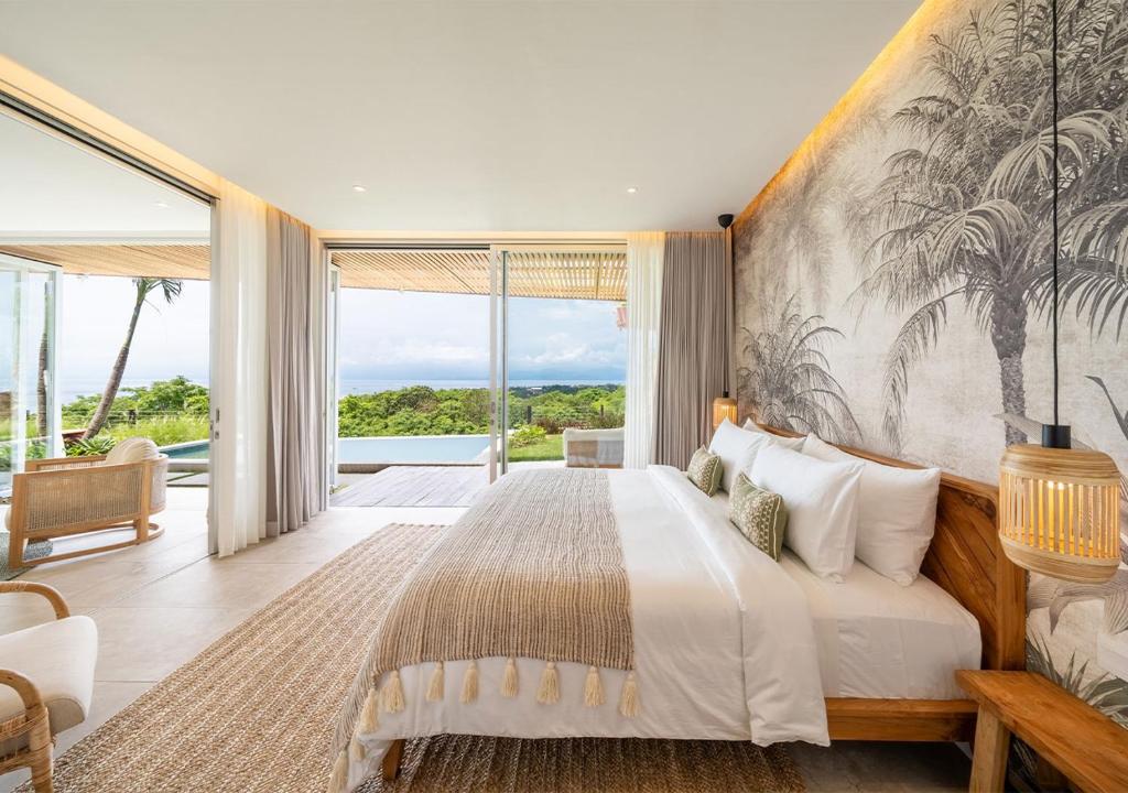 een slaapkamer met een groot bed en een groot raam bij Villa Utopia in Nusa Lembongan