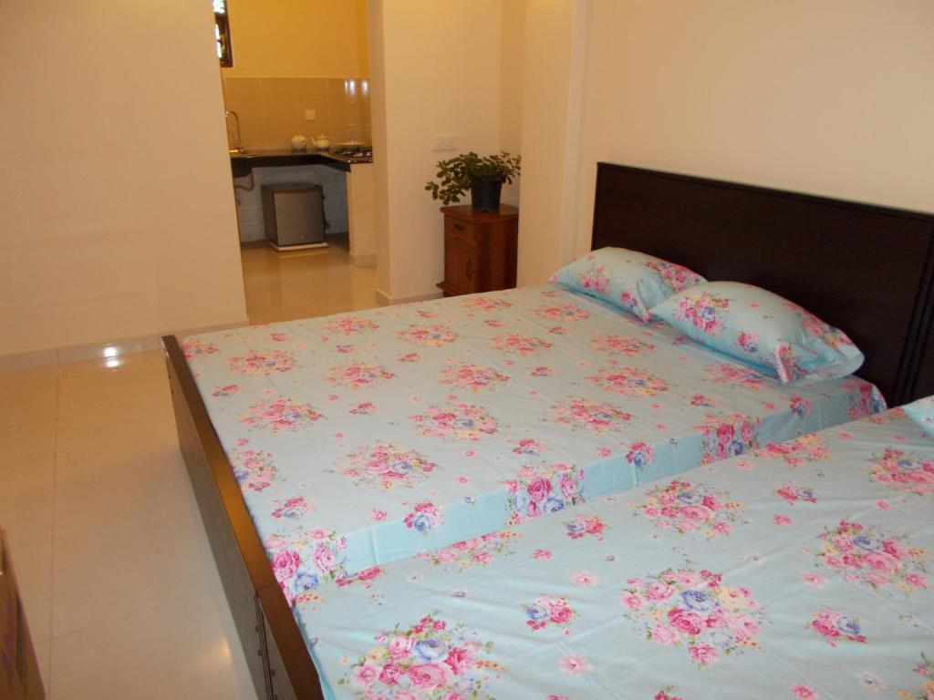 a bedroom with a bed with pink flowers on it at Bedroom with Pantry in Mount Lavinia